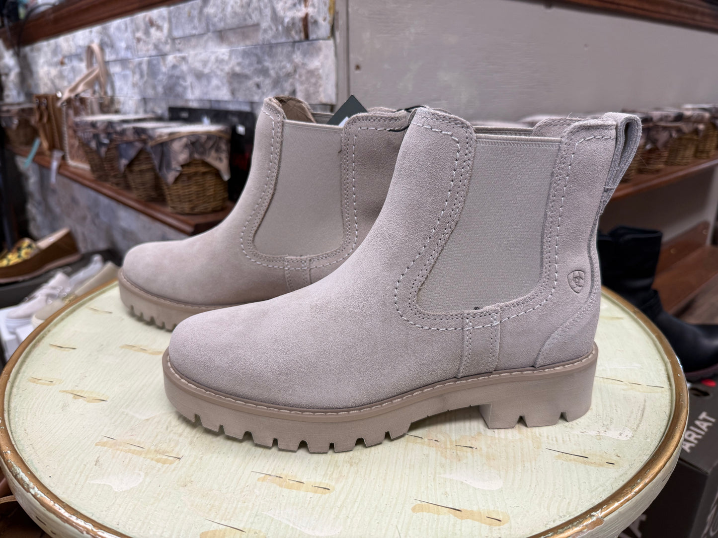 Pair of gray boots on a round surface with a blurred background