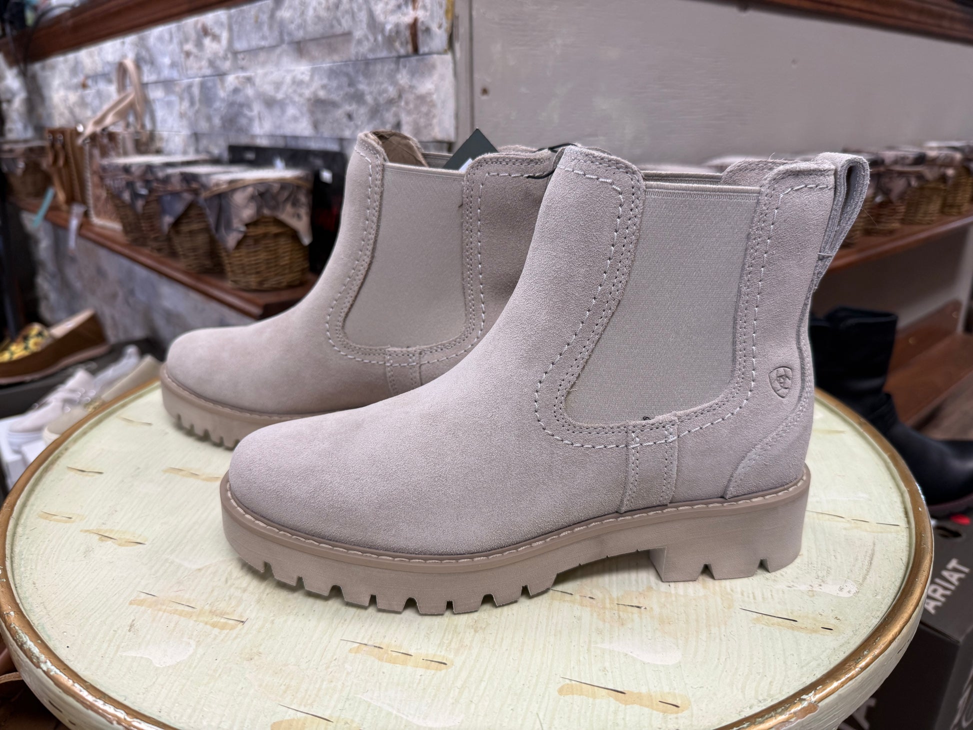 Pair of gray boots on a round surface with a blurred background