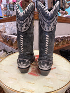 Pair of gray cowboy boots with white stitching on a decorative surface.