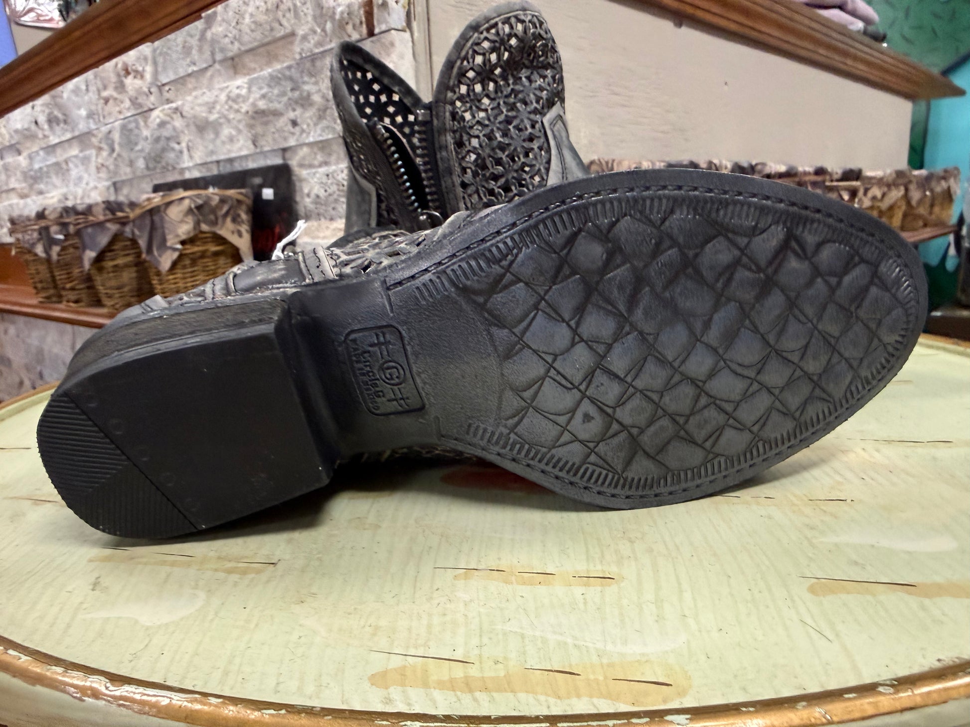 Black boot sole with brand logo on a wooden surface