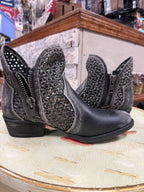 Pair of black boots with intricate designs on a textured surface