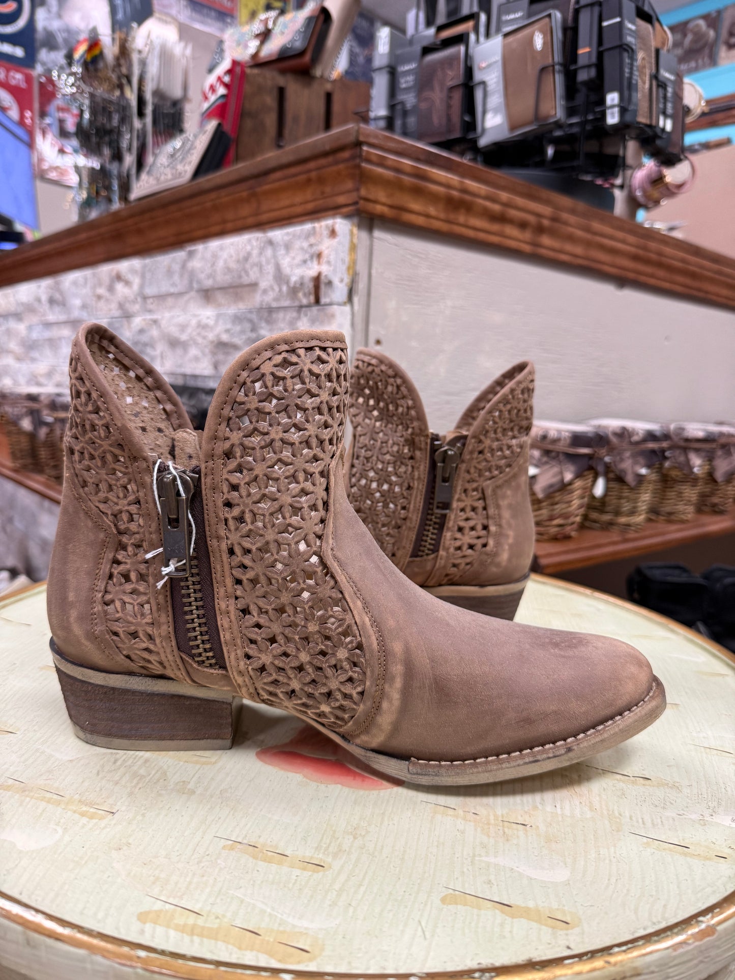Brown lace-up boots on a round surface with a store interior background