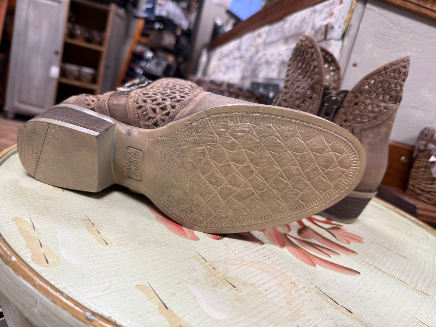 Close-up of brown boots with textured sole on a patterned surface