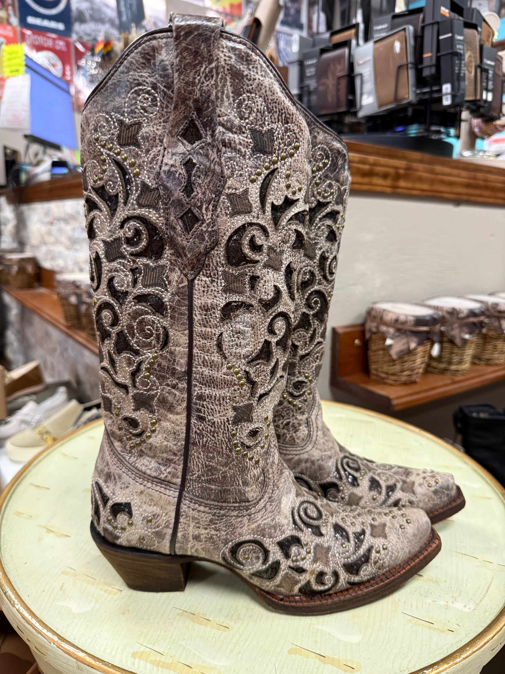 Pair of decorative boots on a stool in a store setting