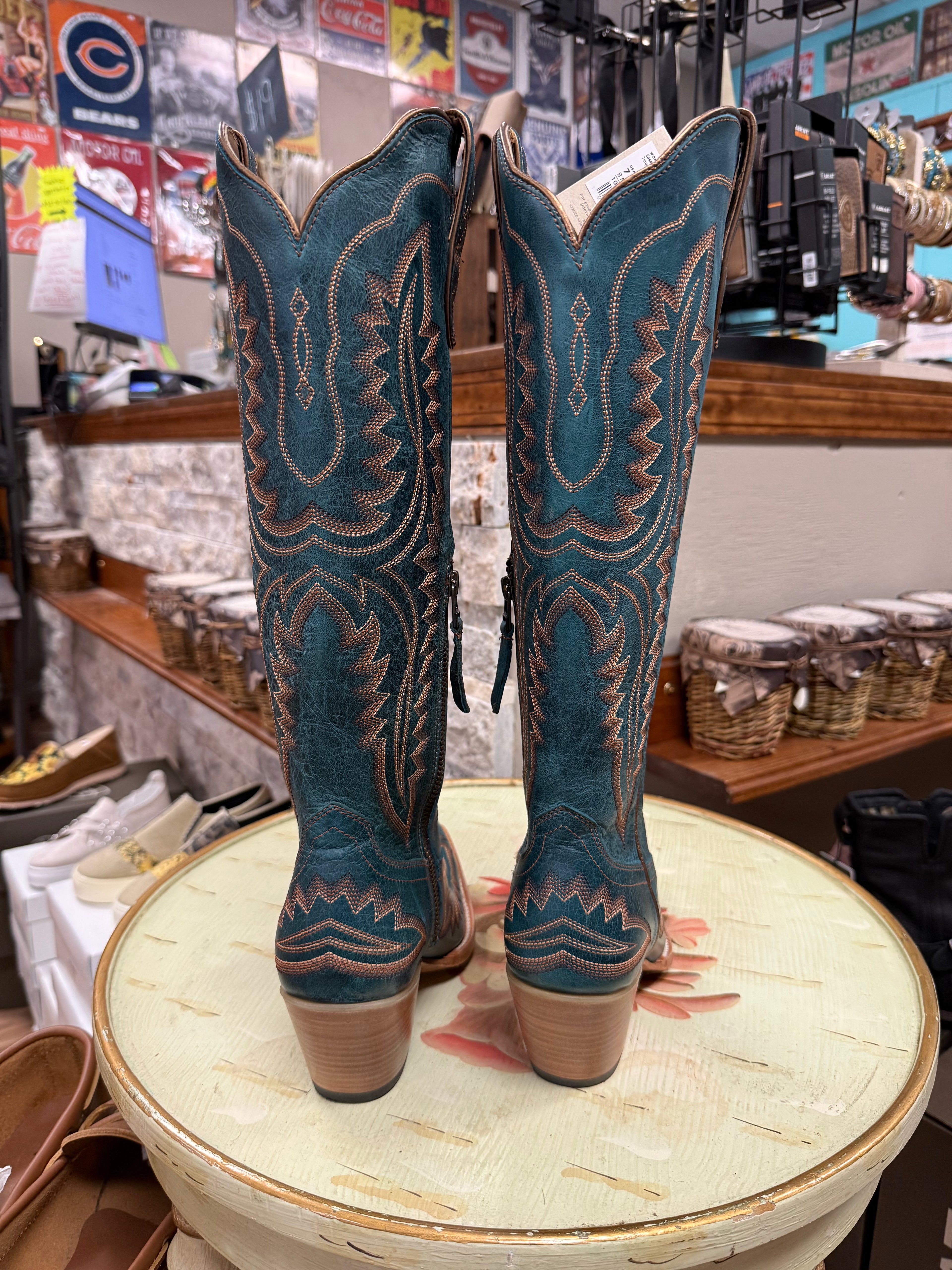 Pair of blue cowboy boots on a round table with a store interior background
