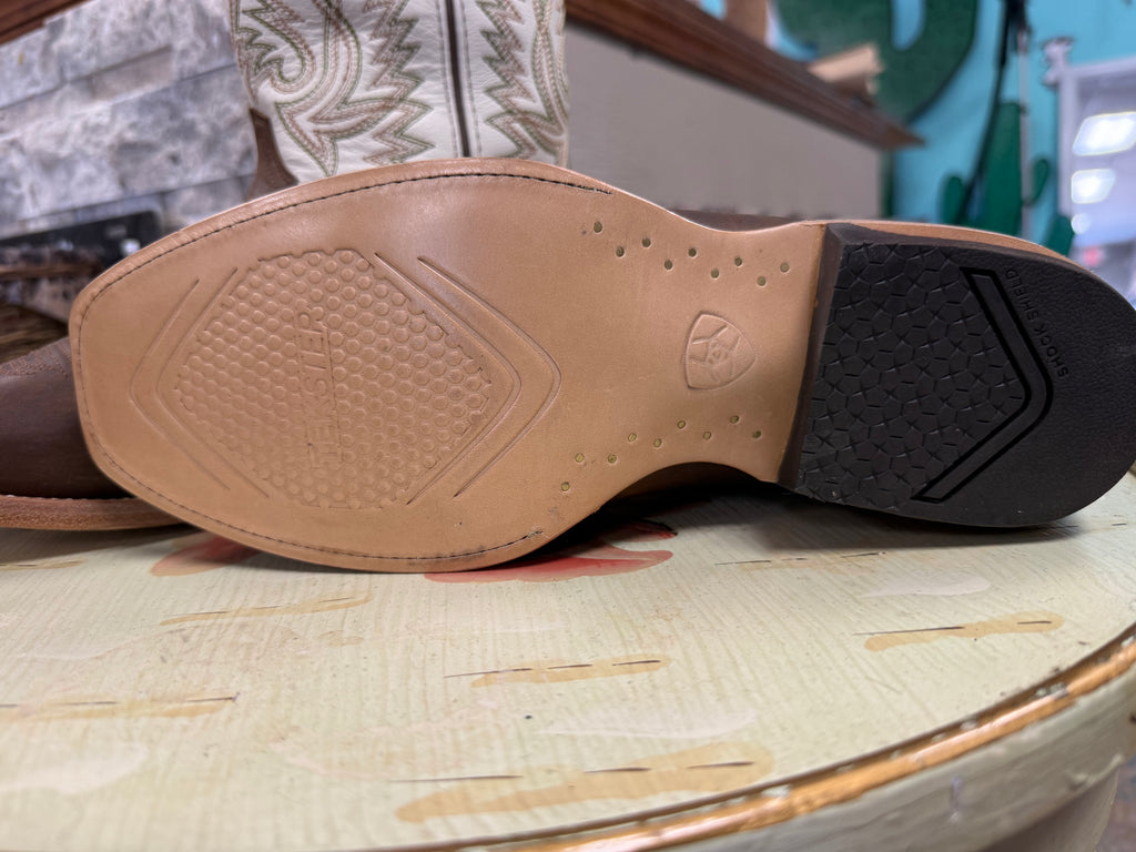 Close-up of a brown leather shoe sole with a brand logo on a textured surface.