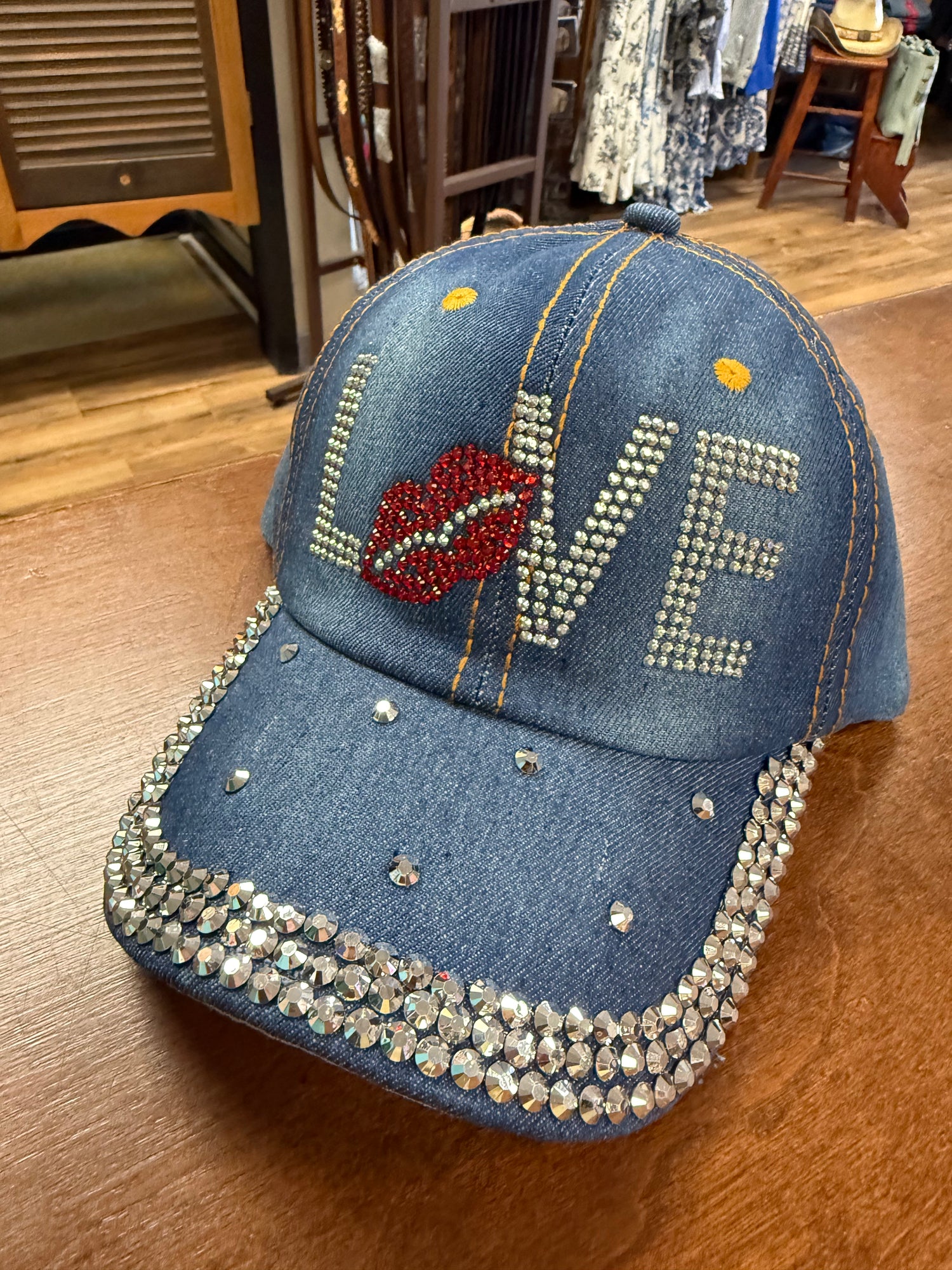 Denim cap with 'LOVE' and heart design on a wooden surface