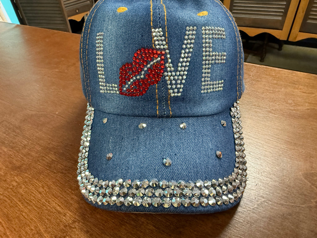 Blue denim cap with 'LOVE' and heart design on a wooden table