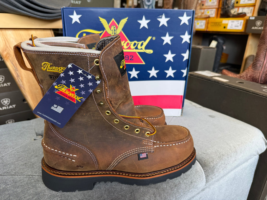 Brown work boots with a tag in front of a Patriotic American flag display.