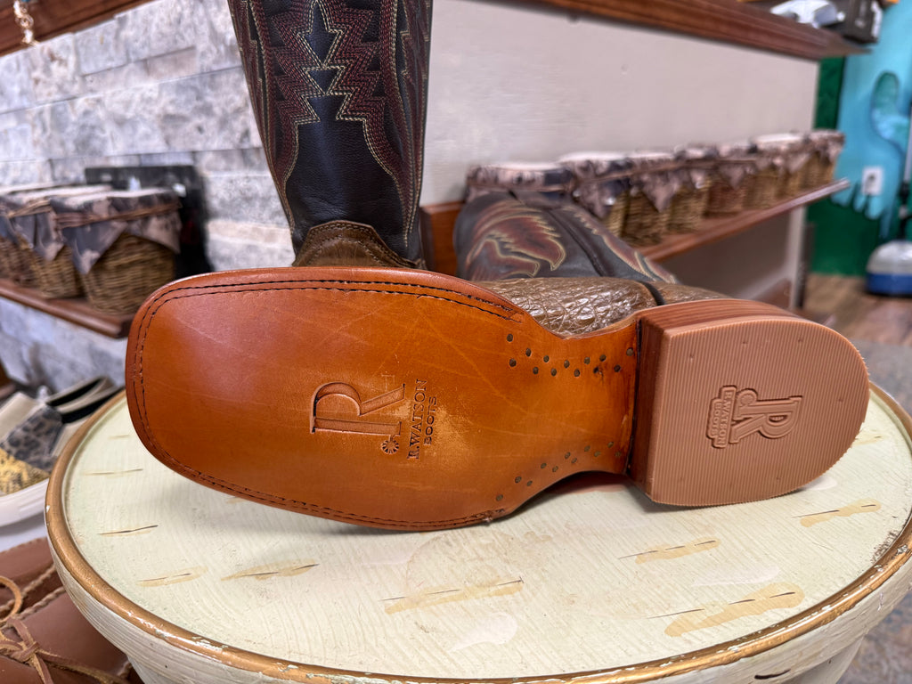 Close-up of a brown leather boot sole with branding on a textured surface.