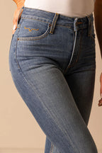 Close-up of blue jeans with a beige background