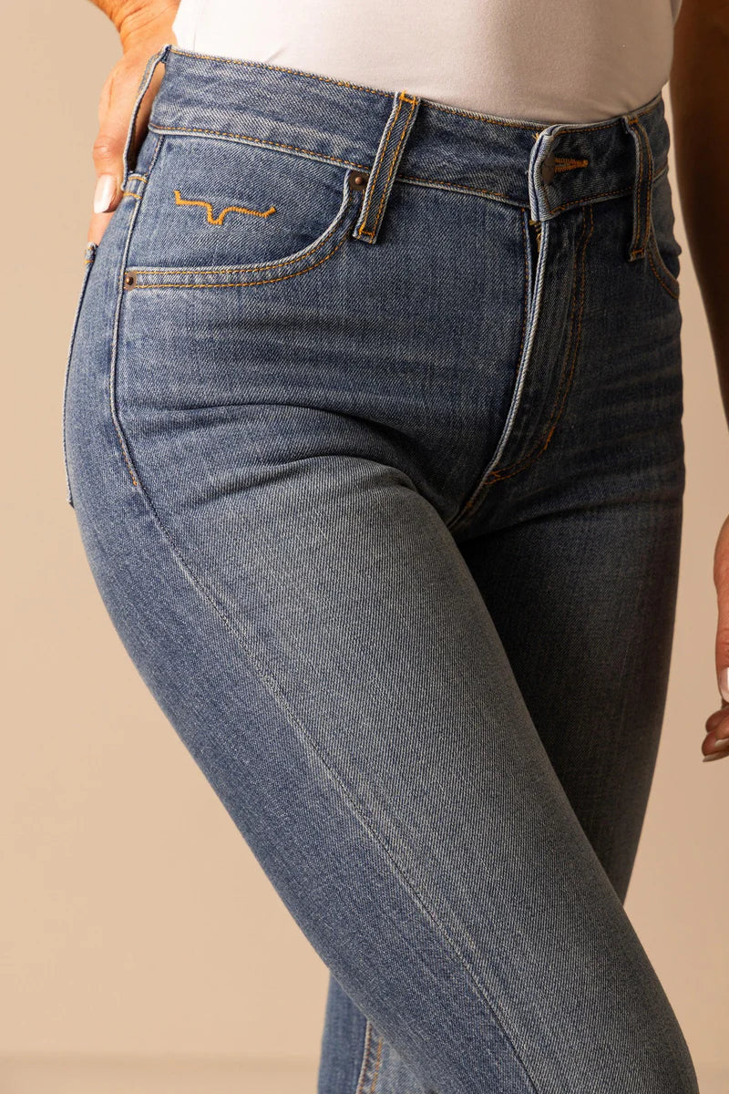 Close-up of blue jeans with a beige background