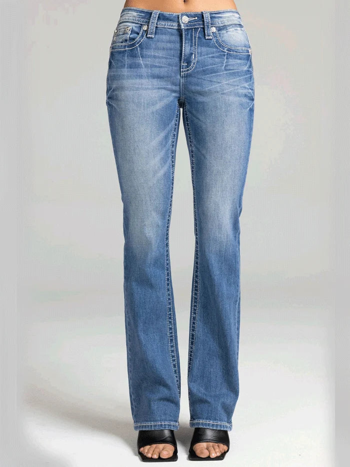 A person wearing light blue denim jeans with a straight-to-medium leg fit, shown from the waist down against a light gray studio background.