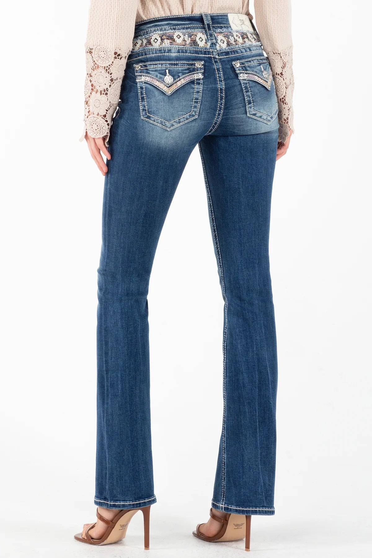 A pair of blue bootcut jeans with contrast stitching and a faux flap pocket design, displayed on a mannequin.