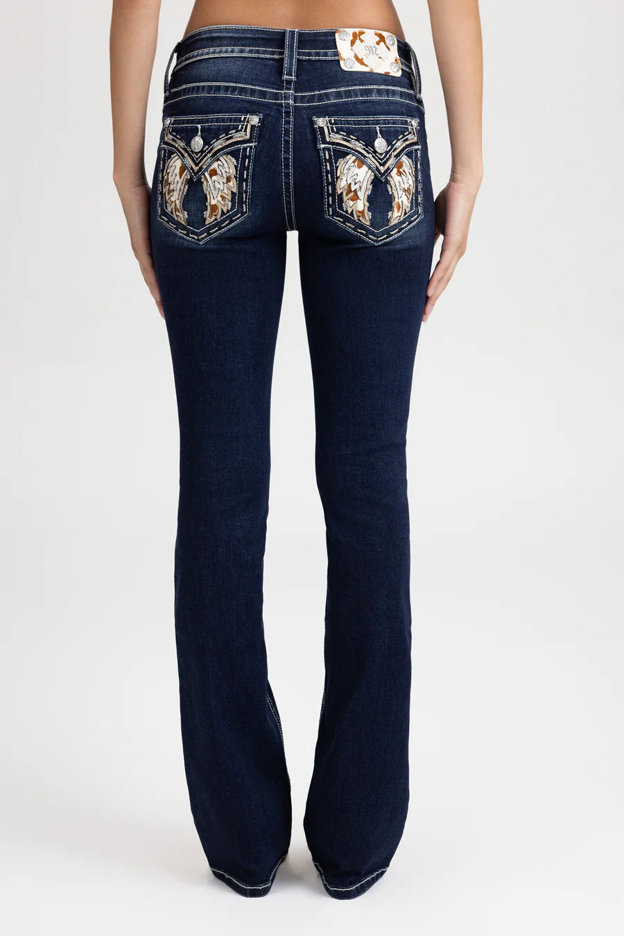 Navy blue jeans with decorative back pockets on a white background