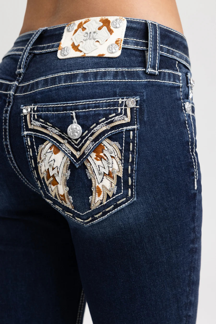 Close-up of dark blue jeans with decorative back pocket and brand logo.
