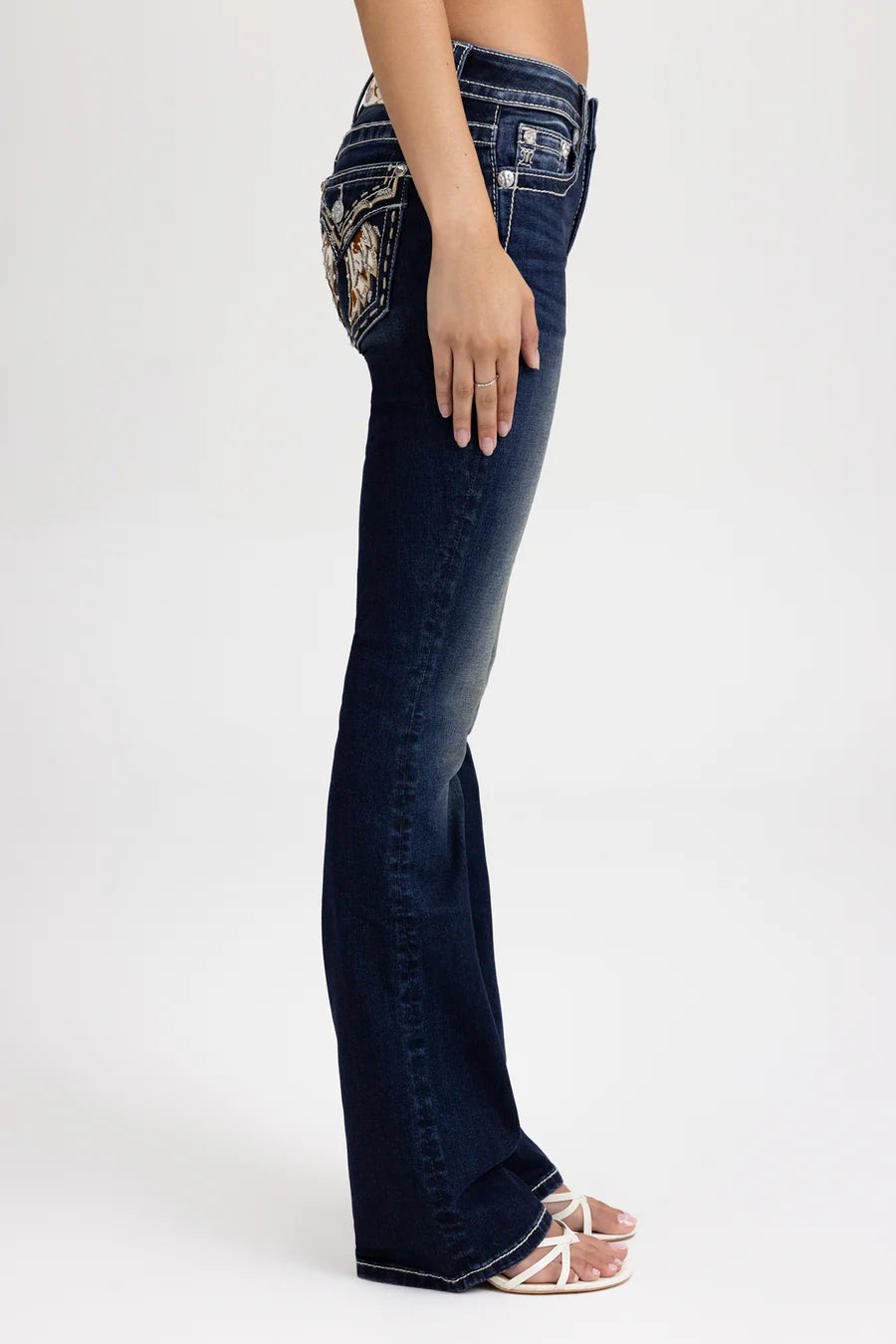 Dark blue jeans with decorative stitching on a white background