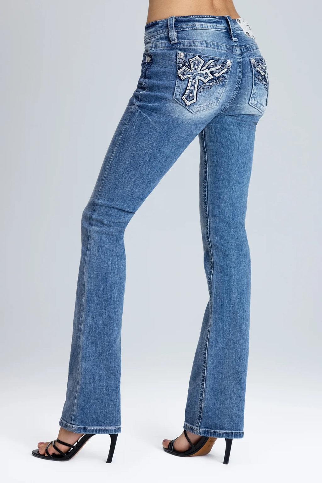 Blue jeans with a decorative cross on a white background