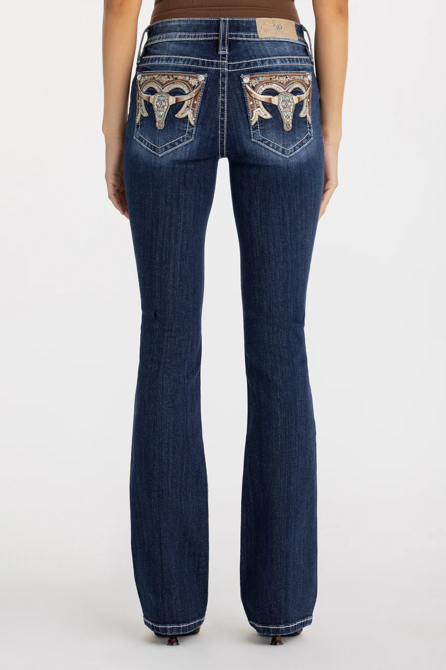 Blue jeans with decorative stitching on the back pockets against a white background
