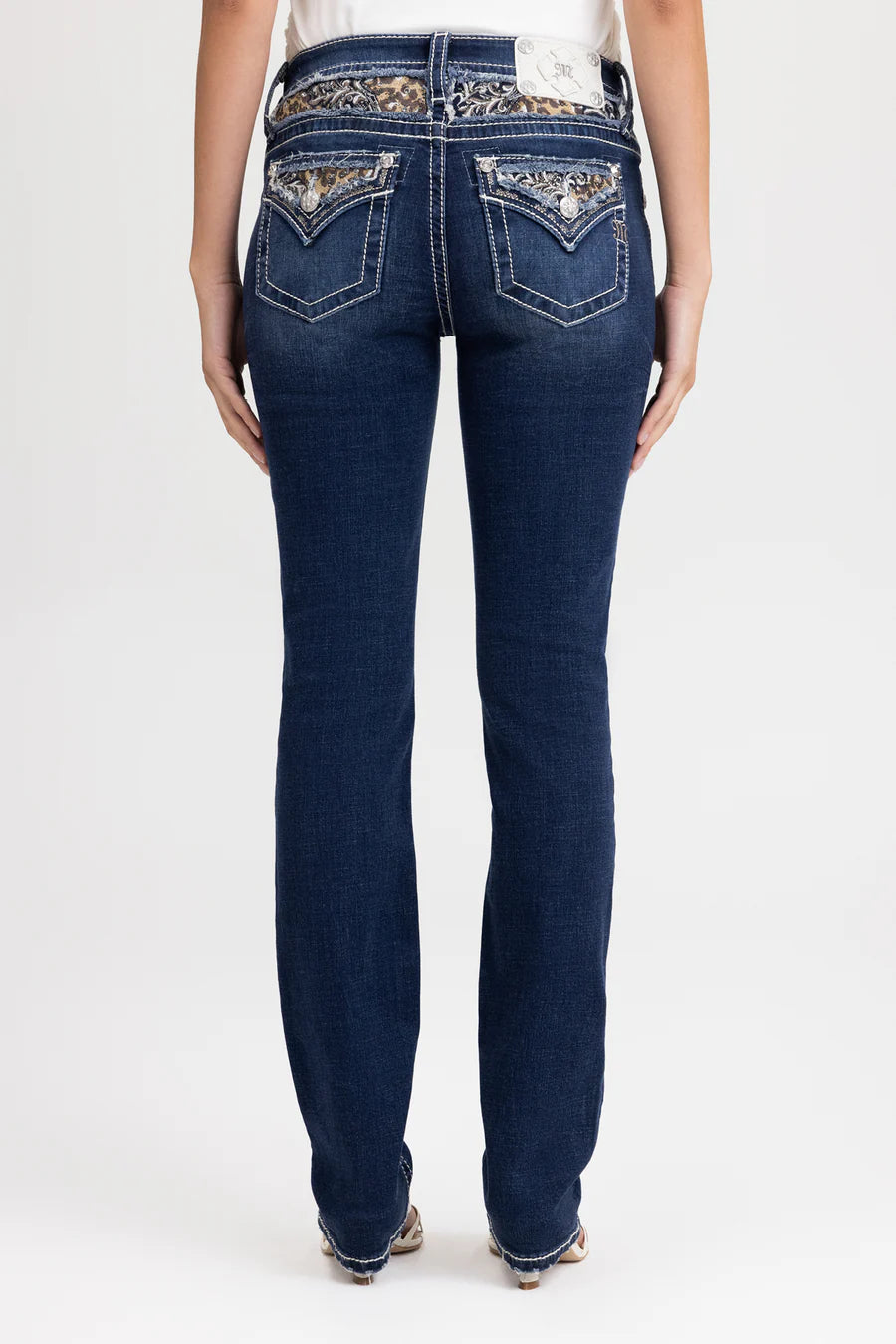 Blue jeans with embellished pockets on a white background