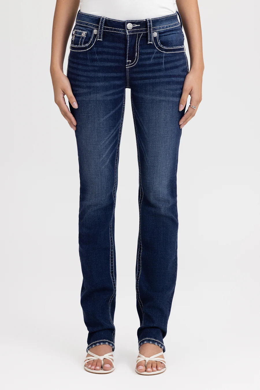 Person wearing dark blue jeans on a white background