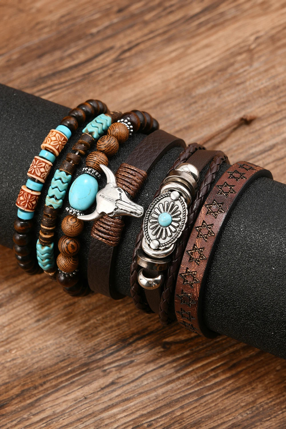 Stack of leather and beaded bracelets with turquoise stones on a wooden surface