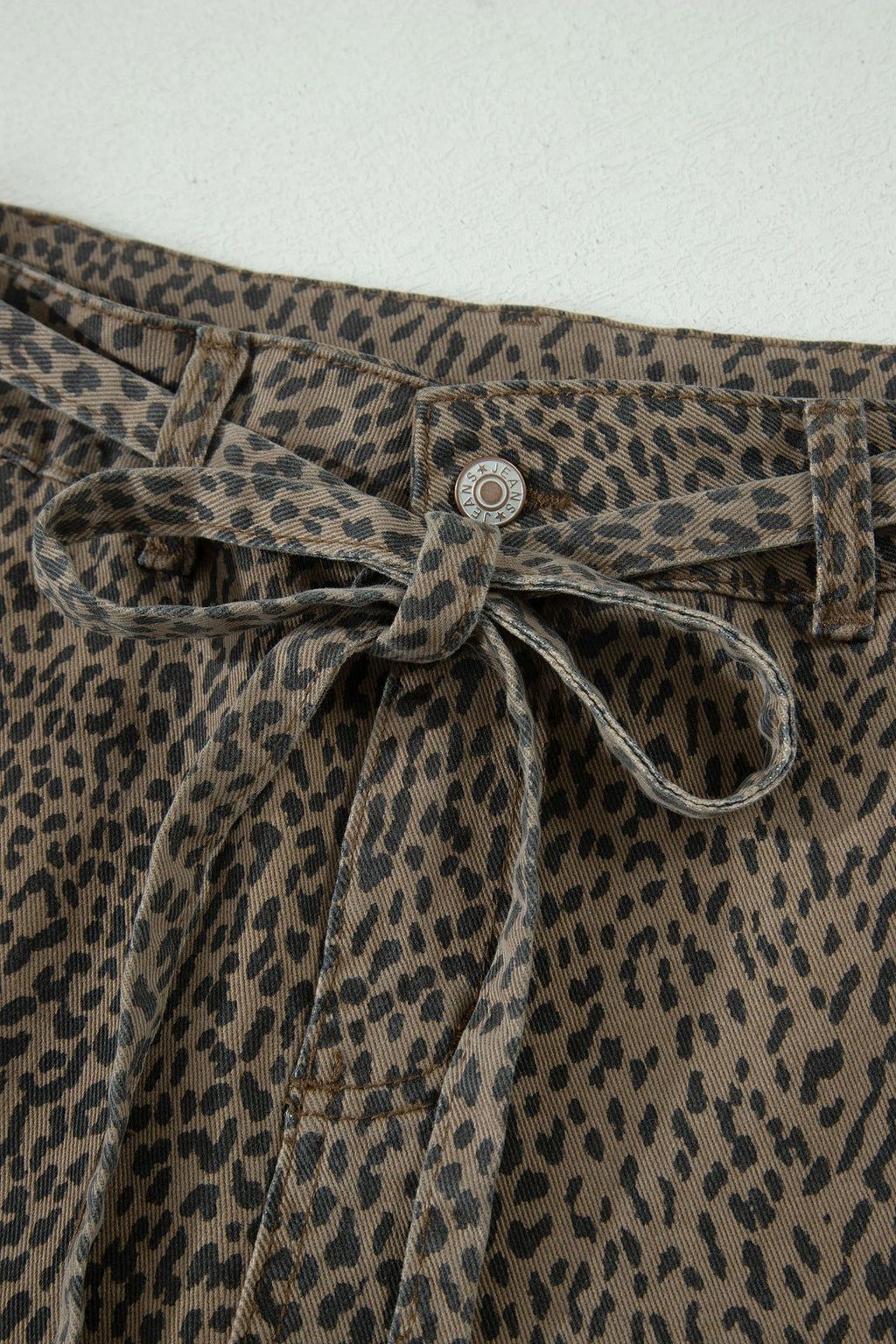 Leopard print pants with a tie waist on a white background