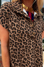 Person wearing a leopard print coat with a colorful scarf and necklace.