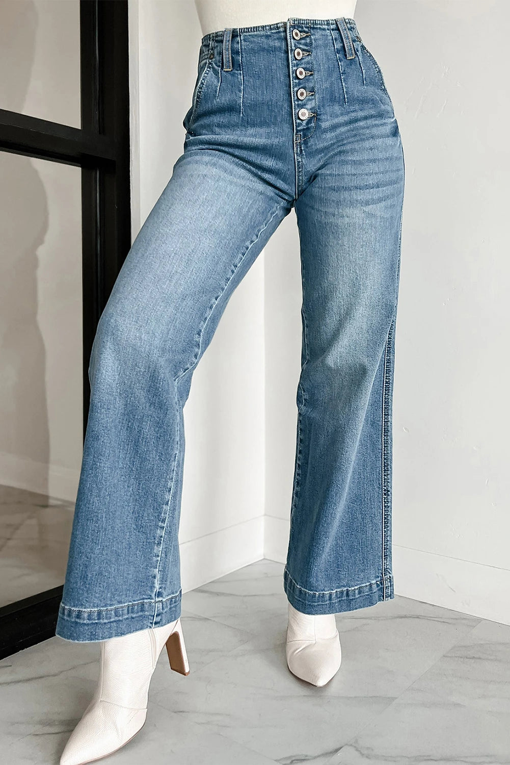Blue jeans worn by a mannequin on a light gray background