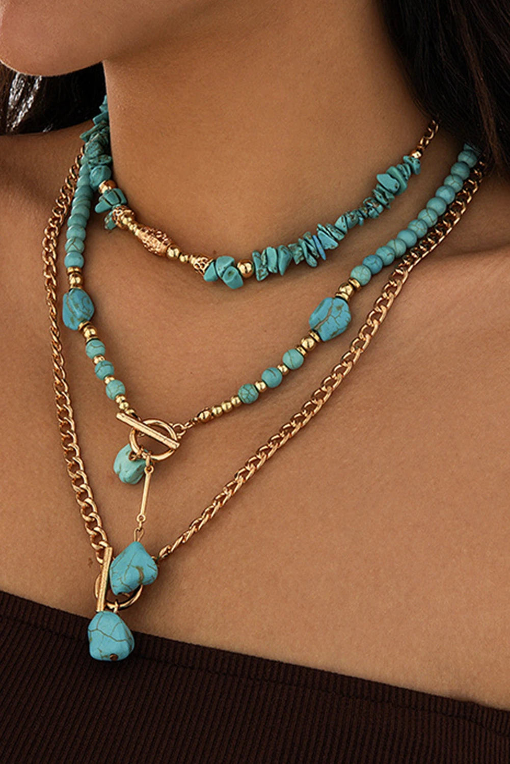 Necklace with turquoise beads and gold chain on a person's neck