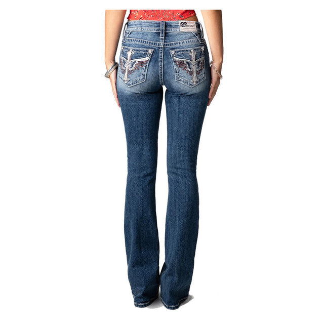 Person wearing blue jeans with decorative stitching on a white background